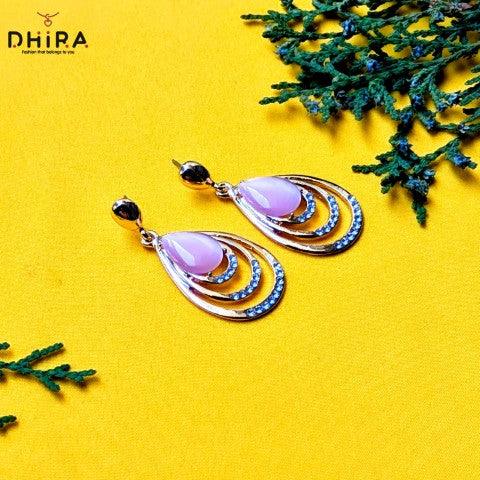 Elegant teardrop gold earrings with pink stones and blue accents on a yellow background