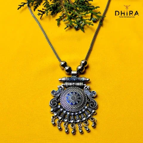 Oxidized silver pendant necklace with intricate floral design on yellow background
